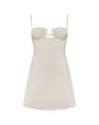 A white, crocheted dress with thin straps. The bodice is fitted and showcases a delicate, tight-knit crochet pattern, while the cut-out detail just below the bust is bordered by a slightly thicker, more open crochet weave, creating a subtle contrast. The skirt portion of the dress continues with a mix of tight and loose crochet patterns. 