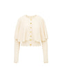 Cream-colored ribbed cardigan with long sleeves, gold button-down front, and a layered design featuring scalloped edges at the hem and cuffs.