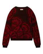 Dark-colored sweater featuring a bold red floral pattern with large flowers covering most of the surface, and a small label at the back of the neck.