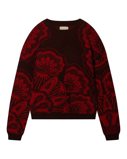 Dark-colored sweater featuring a bold red floral pattern with large flowers covering most of the surface, and a small label at the back of the neck.