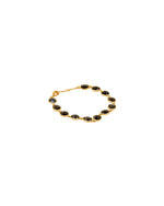 Gold bracelet featuring multiple dark-colored oval gemstones, each set in individual bezels, with a clasp for fastening.