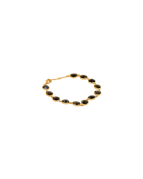 Gold bracelet featuring multiple dark-colored oval gemstones, each set in individual bezels, with a clasp for fastening.