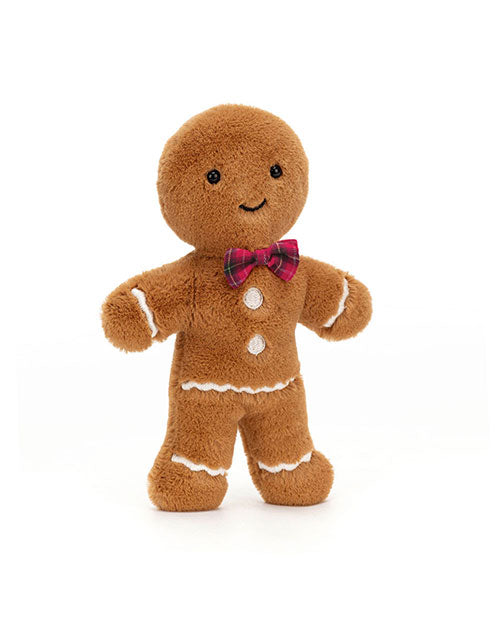 Plush toy shaped like a gingerbread man, featuring black button eyes, a curved smile, white icing-like details on the wrists, ankles, and waist, two white buttons on the chest, and a red and green plaid bow tie around the neck.