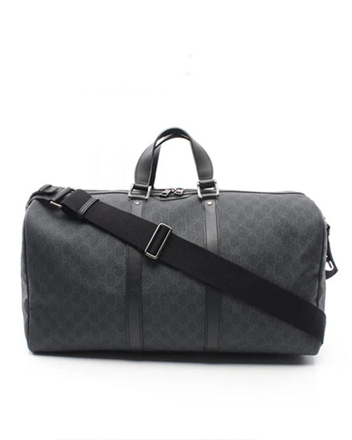 A sleek black Gucci duffle bag with a subtle gray pattern, featuring sturdy handles and a versatile adjustable shoulder strap, set against a clean white background.