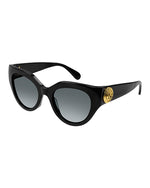 Black narrow cat-eye sunglasses with dark grey lenses and a gold circular logo on the temples.