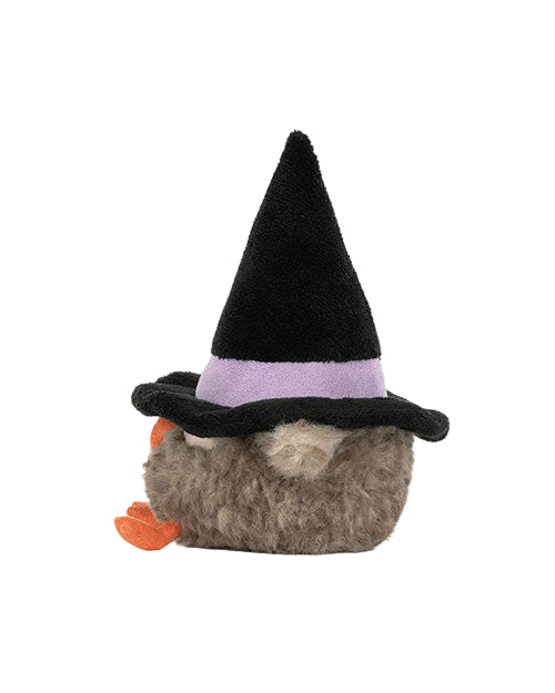 Plush bird toy with fluffy grayish-brown fur, orange feet, and a black witch hat with a purple band.