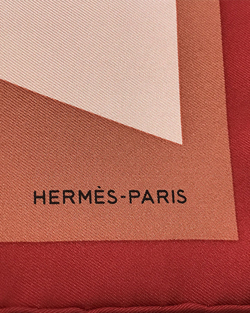 Closeup of silk silk scarf showing "Hermes Paris" on one of the corners.