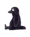 Plush toy resembling a bird with dark purple fur, a large beak, and big white eyes, sitting upright with legs stretched out in front.