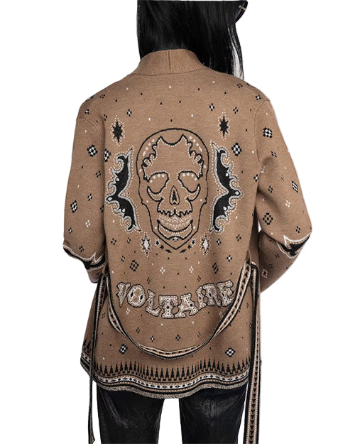 Back view of a person wearing a brown jacket with intricate designs, featuring a large skull with bat-like wings and the word "VOLTAIRE" in stylized text below. The jacket also includes small geometric patterns.