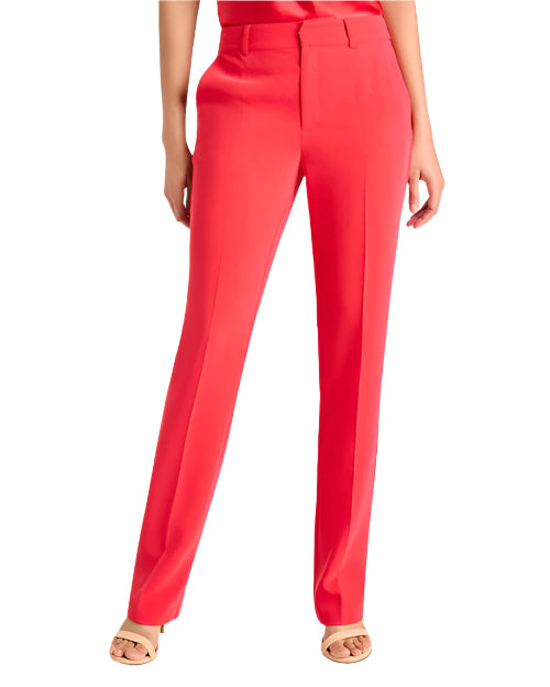 Person wearing bright red dress pants with front creases and beige open-toe sandals, standing against a white background. Image only shows waist down of model.