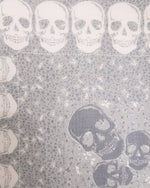 Close up of a pattern of skulls on a textured gray background