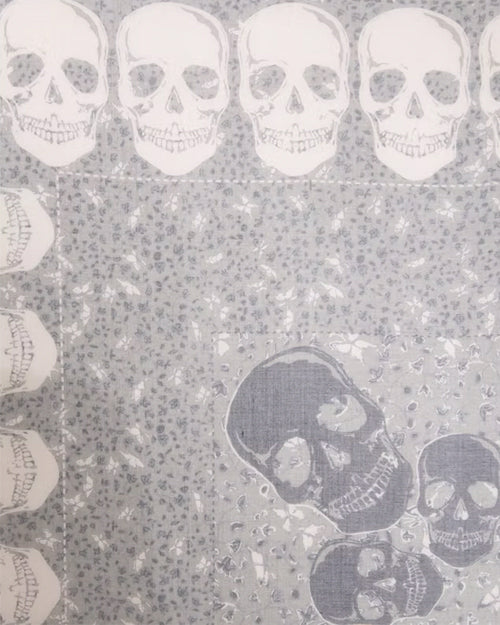 Close up of a pattern of skulls on a textured gray background