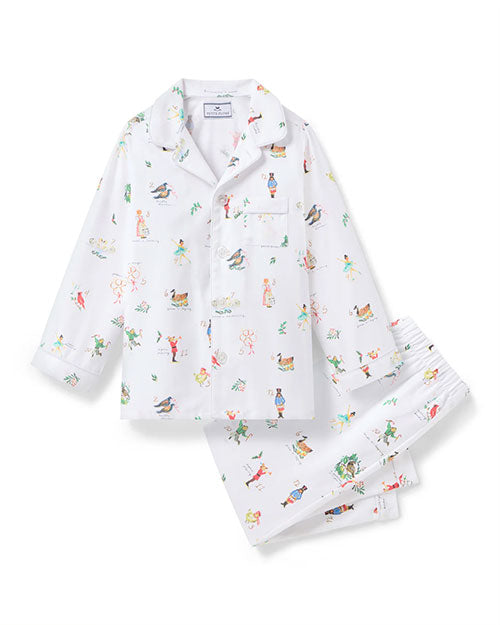  Children's white pajama set with a long-sleeved, collared button-up shirt featuring a chest pocket, and matching pants with an elastic waistband. The fabric is decorated with colorful, playful illustrations of various characters and animals.