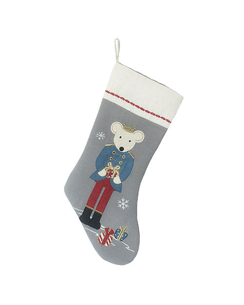 A festive Christmas stocking featuring a mouse in a blue jacket with a crown, holding a gift. The background is gray with snowflakes and presents.