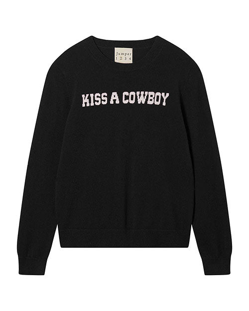 Black sweater with white capital text 'KISS A COWBOY' across the chest and a neckline label reading 'Jumper 1234'