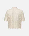 Back view of a beige short-sleeved, lace blouse with a floral pattern. The blouse features a collar and a front button closure, and scalloped edges on the sleeve and hem.