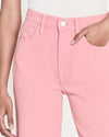 Close-up of a model wearing light-pink denim trousers. The trousers have visible white stitching along the seams and pockets. 