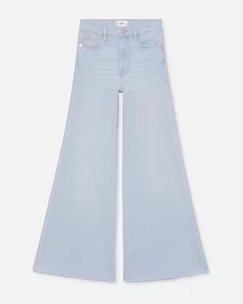 A pair of high waisted light blue flared jeans. The jeans are frayed at the hem.