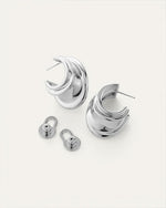 Pair of silver hoop earrings with a unique, layered design; includes two silver earring backs with circular bases and oval loops.