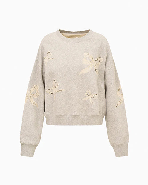 Light gray sweatshirt with long sleeves and a crew neckline, featuring multiple bow-shaped cut-out designs across the front and sleeves, revealing a lighter lace underneath for contrast.