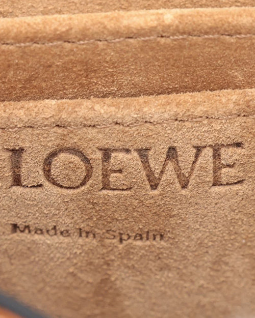 Close up of Loewe made in Spain embossed on light brown suede leather.