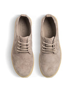Top view of a pair of beige suede shoes on a white background