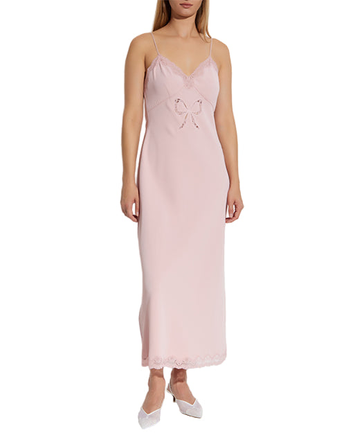 Woman wearing a pink slip dress on a white background