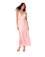 Woman wearing a pink a slip satin dress  with gold sandals on a white background
