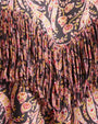 Close-up of a paisley pattern in pink, yellow, and black, featuring fringe detailing