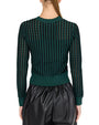 back view of a  person wearing a green and black vertically striped sweater with long sleeves