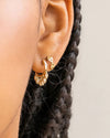 Close-up of a person’s ear wearing two hoop earrings.