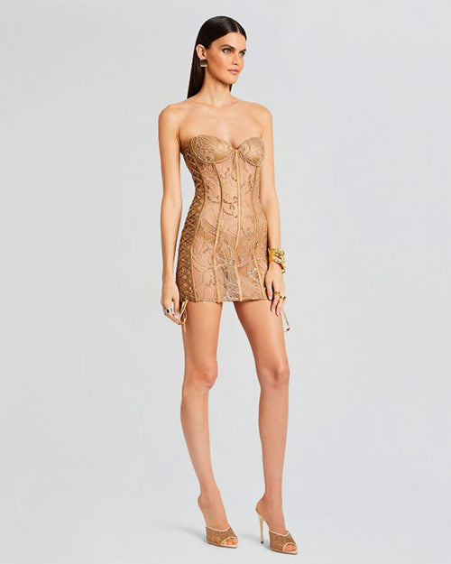 A side view a tan lace mini dress. The dress features a strapless, sweetheart corset bodice with boning detail throughout. The dress has oversized ties at each side, with a classy sheer design.