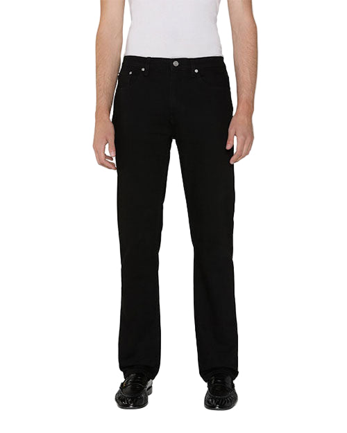 Front view of a person standing upright, wearing black pants, black shoes, and a white shirt.