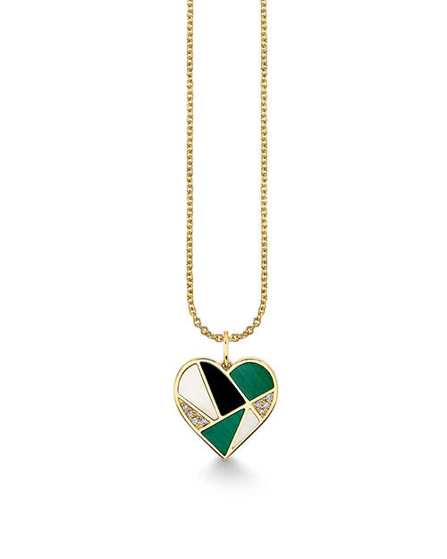 A pendant necklace featuring a heart-shaped charm with a gold outline. The charm is divided into different sections, alternating between green, black, pave diamonds, and white enamel inlays, creating a striking geometric pattern. The pendant is suspended from a delicate gold chain that complements the charm’s elegant design.