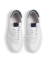 Top view of a pair of white sneakers with navy accents on a white background