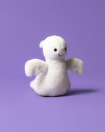 Small white plush toy with a smiling face and outstretched arms, set against a solid purple background.