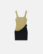 A dress with an asymmetrical black mini skirt design and a distinct green tank top with a square neckline, laid in front of a plain background.