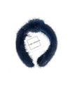 A navy mink fur headband with a knot in the middle. The label has black text that reads “linda richards NEW YORK.” 