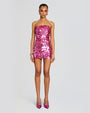 A model wearing a strapless, bright pink sequined mini dress. The dress is form-fitting and falls to mid-thigh. Paired with the dress are pointed-toe high heels in a matching pink hue.