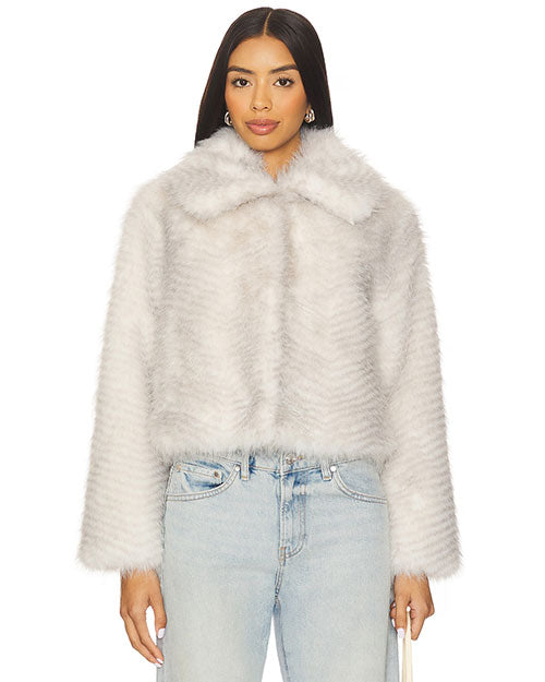 Front view of a light gray faux fur jacket featuring a wide collar, long sleeves, and a soft plush texture, paired with light wash denim jeans.