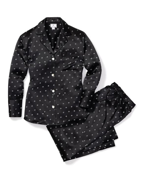 Black silk pajama set with button-up shirt and matching pants, featuring a white motifs. Shirt includes notched collar and breast pocket, pants have elastic waistband.