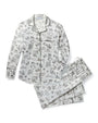 White pajama set with black architectural and cityscape print, featuring a long-sleeved button-up shirt with black piping along the collar, placket, cuffs, and pocket edges, and matching pants with an elastic waistband and drawstring.