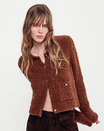 A person wearing a brown cardigan. Image only shows top part of the body.