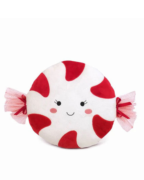 A plush pillow shaped like a peppermint candy, with red and white swirls and pink tulle ends. The pillow has a smiling face and rosy cheeks, conveying a playful and cheerful tone.