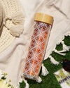 A clear travel infuser mug with white floral patterns. The mug features bamboo lid and infuser.