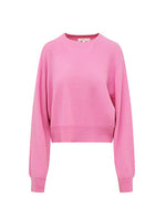 A pink cashmere sweater with a crew neckline and long sleeves. The sweater has a cropped fit, with ribbed cuffs on the sleeves and a ribbed waistband. The fabric appears to be a soft knit texture.