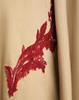 Close-up of a red embroidered design on beige fabric