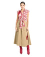 Woman wearing a red floral blouse and beige skirt with red boots on a white background