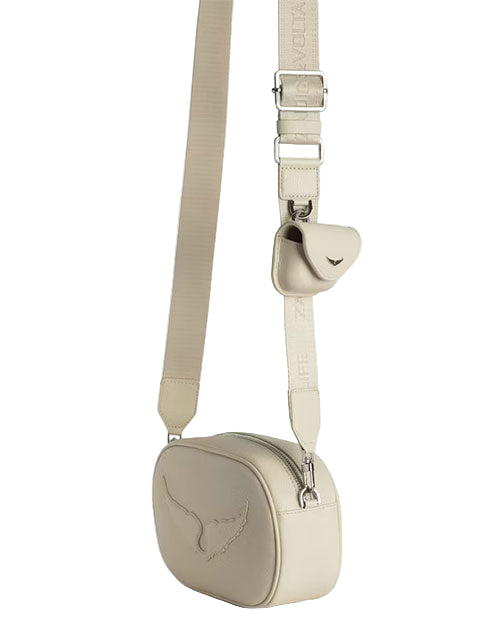 A beige crossbody bag with an adjustable strap, featuring a small pouch attached to the strap and a bird logo embossed on the front. 