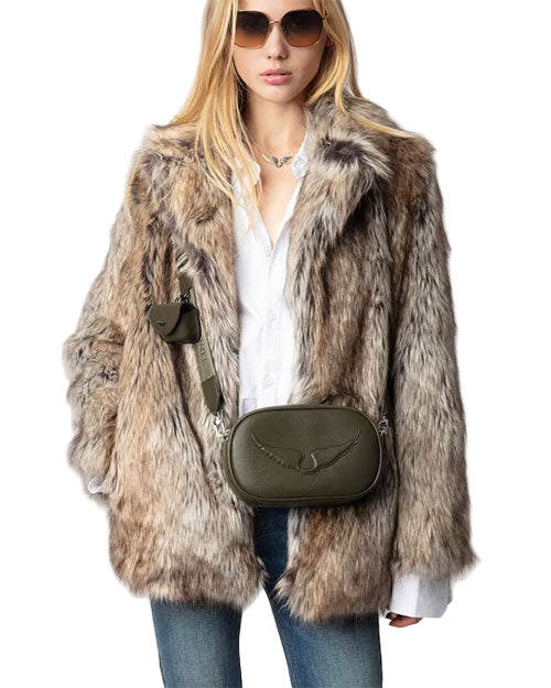 A person wearing dark sunglasses, a fur coat, white shirt, and blue jeans, carrying an olive green crossbody bag with an embroidered design on the front. 